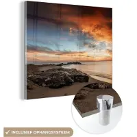 MuchoWow Glasschilderij 50x50 cm - Schilderij acrylglas - Strand - Stenen - Avond - Lucht - Natuur - Foto op glas - Schilderijen