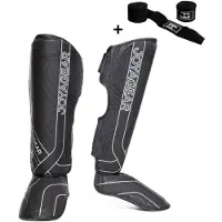 Joya ESSENTIAL Scheenbeschermers – Maat L – Zwart/Wit – Kickboksen/Muay Thai/MMA – Ergonomische pasvorm, schokabsorberende padding – Inclusief Bandage